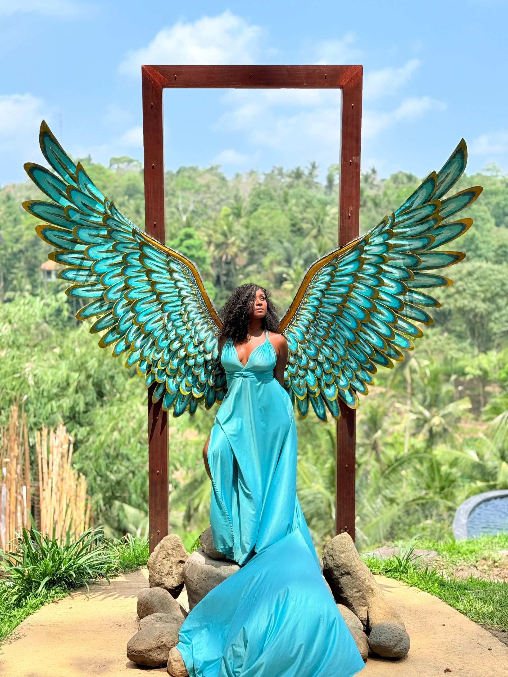 Maradona in a turquoise flying dress with angel wings at a Bali photo spot