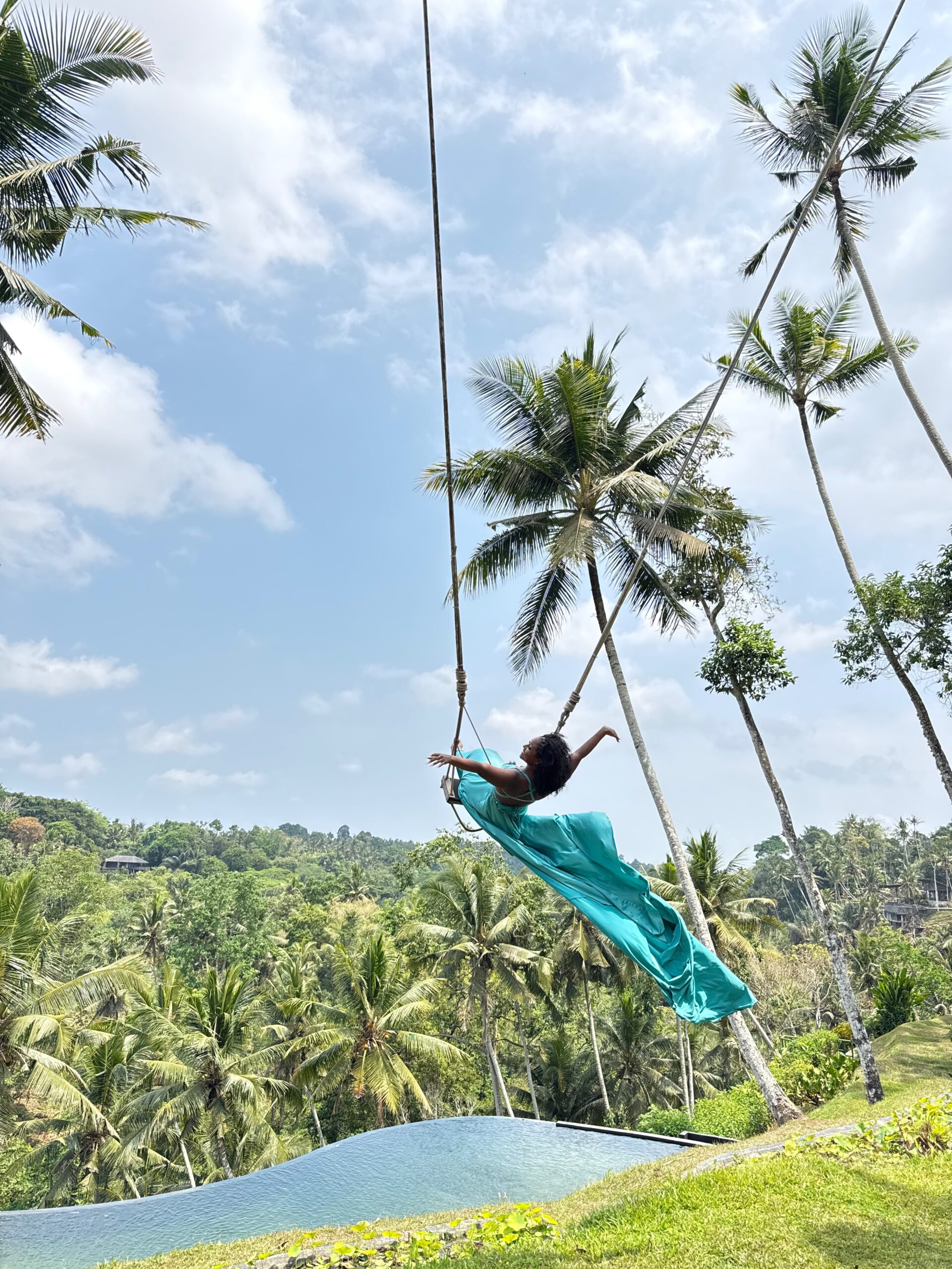 Maradona on the Bali jungle swing in a flowing turquoise dress