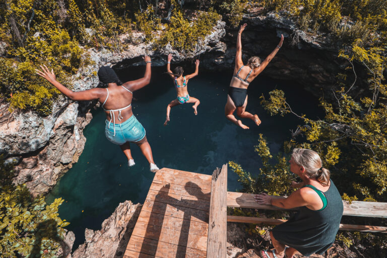 Maradona jumping into a blue hole on an island adventure in The Bahamas