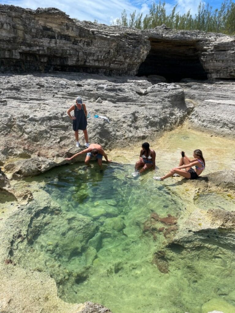 Friends soaking in the Queen's Bath tide pools in Eleuthera